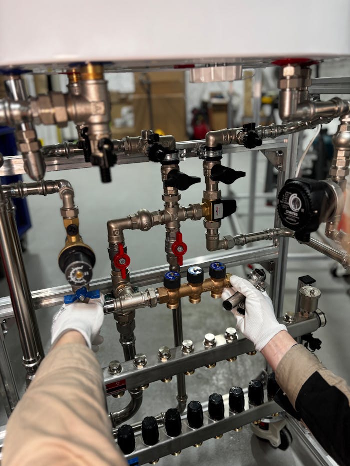 Engineer adjusting metal pipeline valves in an industrial setting with precision.
